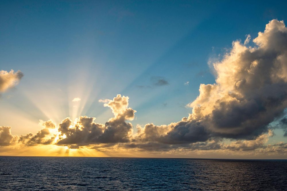 Sunlight breaking through clouds over the ocean